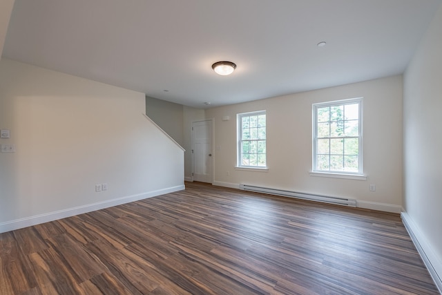 unfurnished room with baseboard heating and dark wood-type flooring