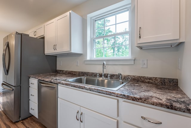 kitchen with white cabinets, sink, appliances with stainless steel finishes, and dark wood-type flooring