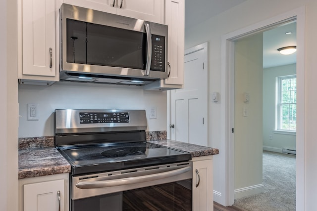 kitchen with carpet flooring, white cabinetry, appliances with stainless steel finishes, and a baseboard radiator