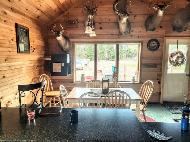 unfurnished dining area with lofted ceiling, wooden walls, and wooden ceiling
