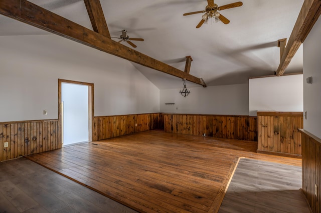 empty room with wood walls, wood-type flooring, vaulted ceiling with beams, and ceiling fan