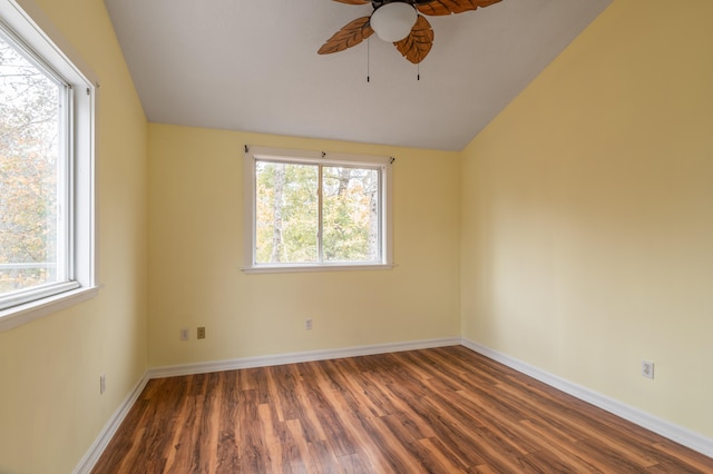 spare room with dark hardwood / wood-style floors, plenty of natural light, and vaulted ceiling