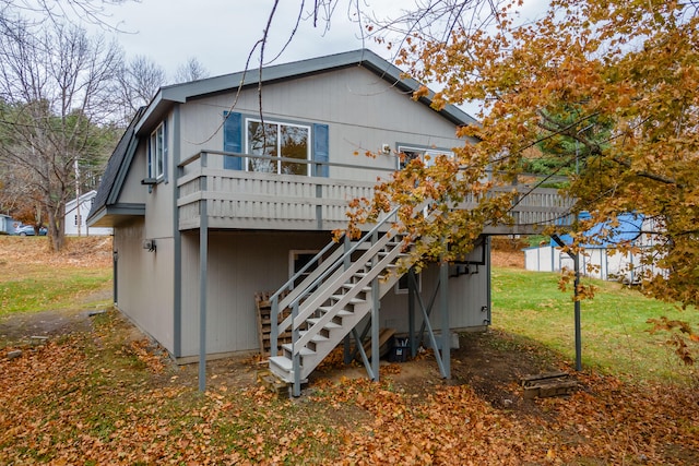 back of house featuring a lawn and a deck