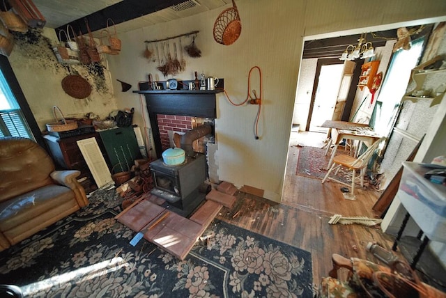 misc room featuring a wood stove, a wealth of natural light, and hardwood / wood-style flooring