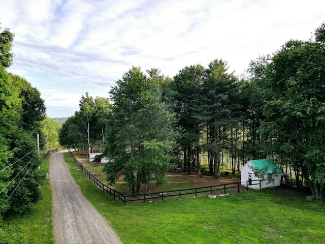 view of property's community with a rural view and a lawn