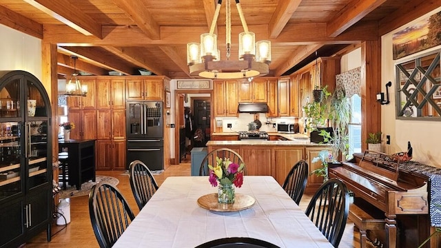 kitchen featuring pendant lighting, black built in refrigerator, wood ceiling, and a chandelier