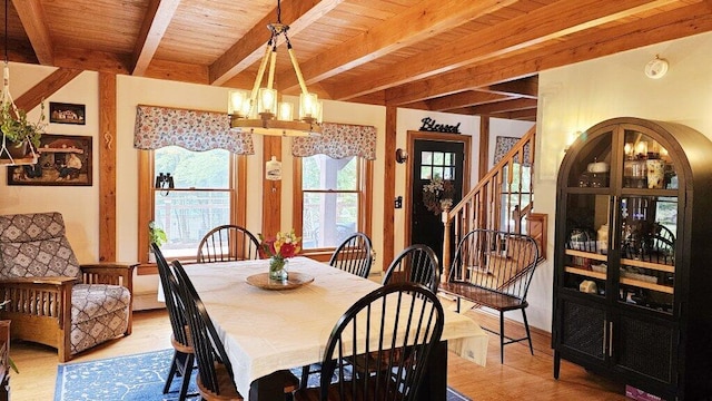 dining area featuring an inviting chandelier, beam ceiling, wooden ceiling, and light hardwood / wood-style floors