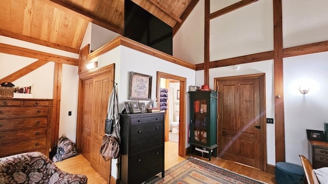 bedroom with ensuite bathroom, wood ceiling, wood-type flooring, high vaulted ceiling, and beamed ceiling