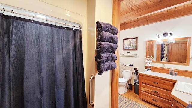 bathroom with hardwood / wood-style floors, vanity, beamed ceiling, wooden ceiling, and toilet