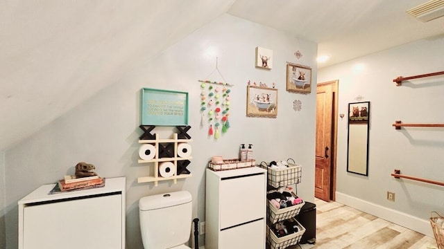 bathroom featuring lofted ceiling, wood-type flooring, and toilet