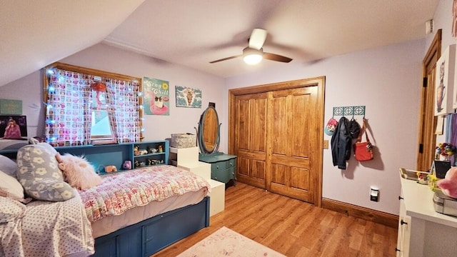 bedroom featuring ceiling fan, lofted ceiling, light wood-type flooring, and a closet