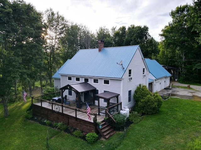 back of house featuring a wooden deck, a gazebo, and a lawn