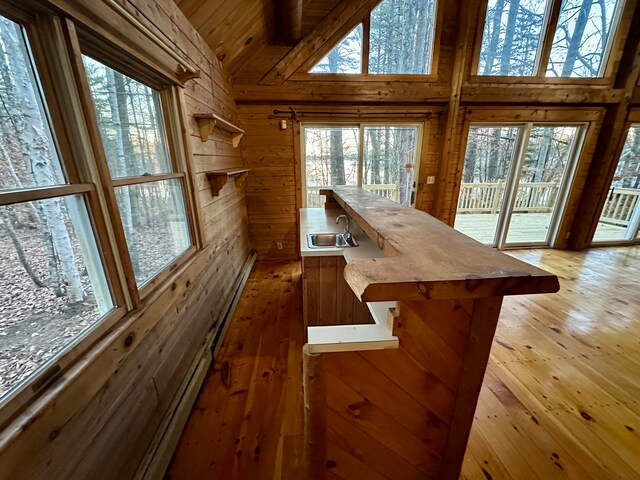 111 Ice Rd, Acton, ME 04001 - bar with wooden walls, hardwood / wood-style floors, high vaulted ceiling, and sink