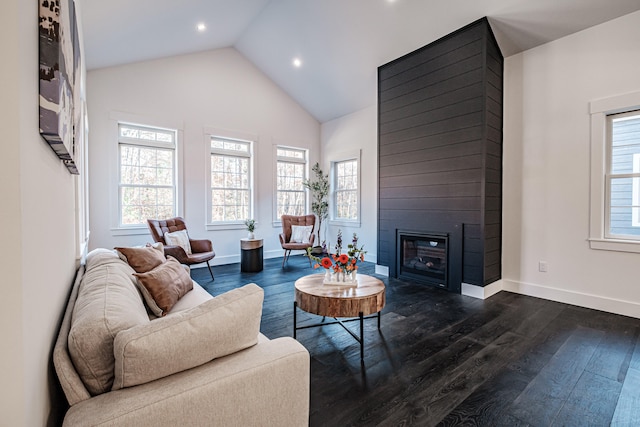 living room with a large fireplace, dark wood-type flooring, and vaulted ceiling