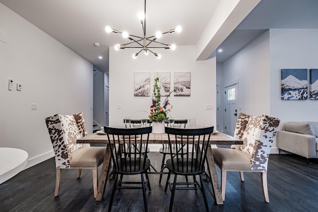 dining area with dark wood-type flooring and an inviting chandelier