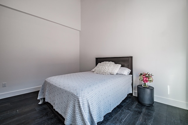 bedroom with dark hardwood / wood-style flooring