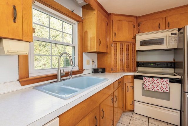 kitchen featuring white appliances, sink, and light tile patterned floors