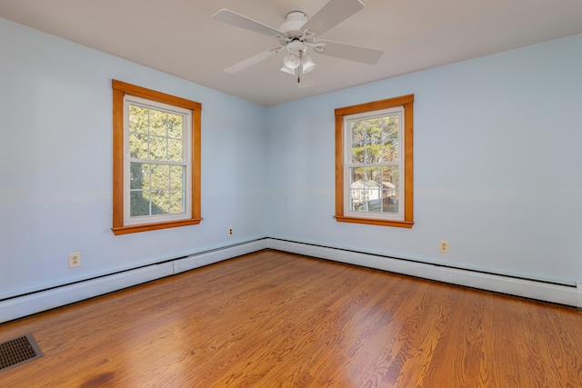 spare room featuring ceiling fan, light wood-type flooring, and a wealth of natural light