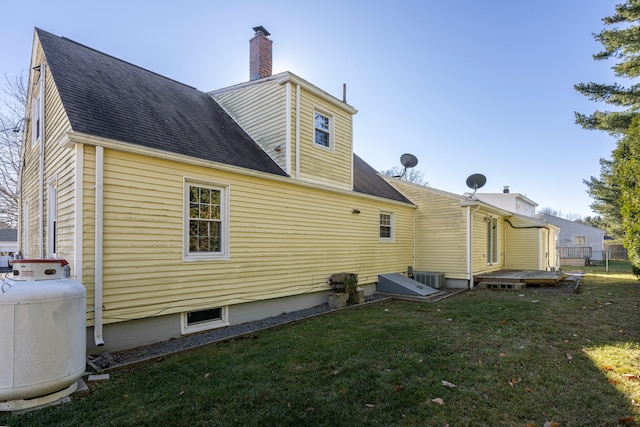 rear view of property with a lawn and central AC unit