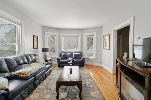 living area with light wood finished floors, baseboards, and a wealth of natural light