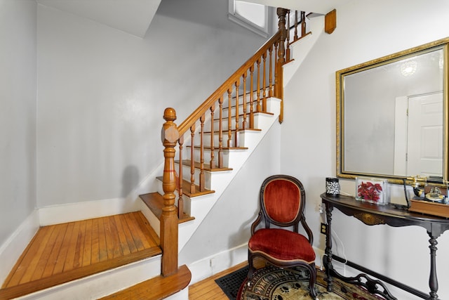 stairs with wood-type flooring, visible vents, and baseboards