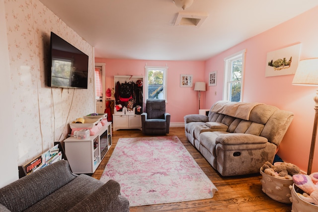 living room with hardwood / wood-style floors and a healthy amount of sunlight