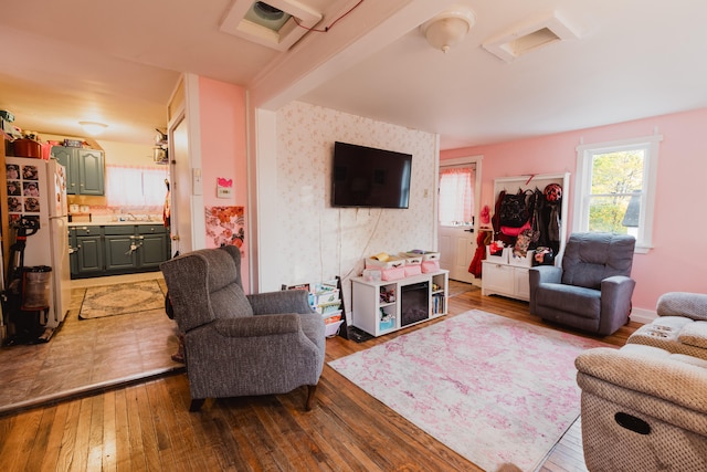 living room featuring hardwood / wood-style floors and beamed ceiling