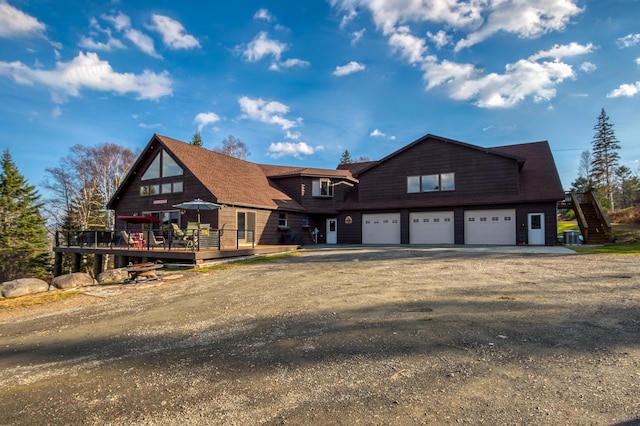 8 Hilltop Hts, Rangeley, ME 04970 - view of front facade with an attached garage, a deck, asphalt driveway, stairway, and central AC unit