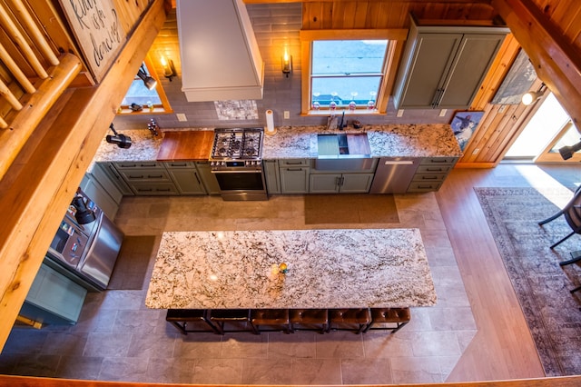 8 Hilltop Hts, Rangeley, ME 04970 - kitchen featuring wall oven, custom exhaust hood, light stone countertops, a sink, and healthy amount of natural light