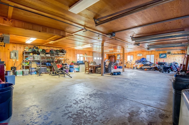 8 Hilltop Hts, Rangeley, ME 04970 - garage featuring electric panel, wooden walls, wood ceiling, and a garage door opener