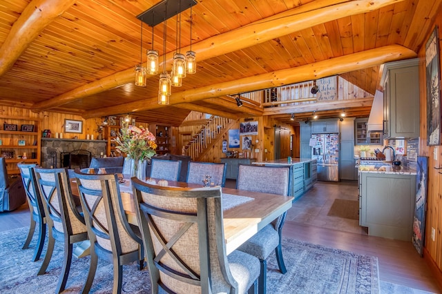 8 Hilltop Hts, Rangeley, ME 04970 - dining space with dark wood-style floors, wood ceiling with exposed beams, stairs, and wood walls