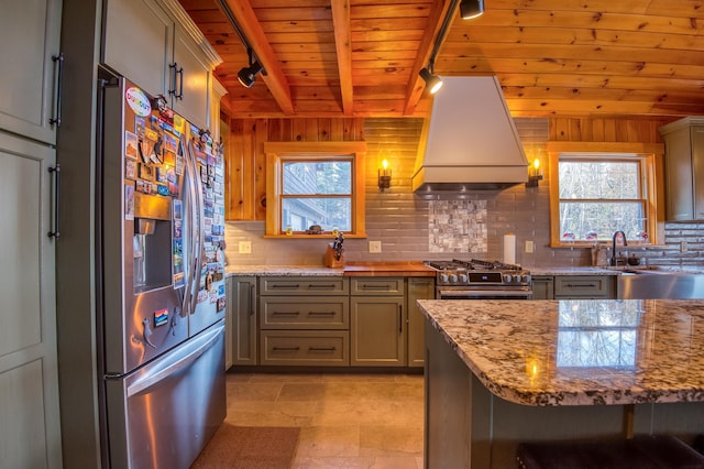 8 Hilltop Hts, Rangeley, ME 04970 - kitchen with appliances with stainless steel finishes, custom exhaust hood, wood ceiling with exposed beams, decorative backsplash, and rail lighting