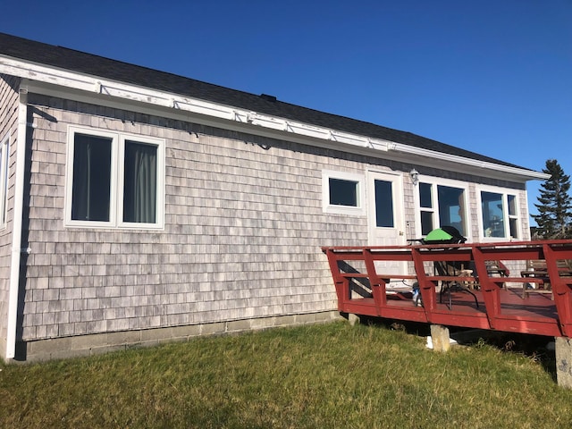 rear view of property featuring a deck and a yard