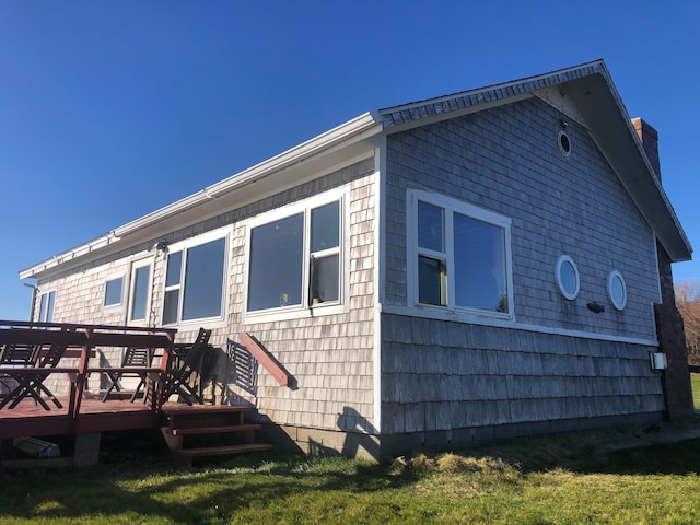 rear view of house featuring a wooden deck and a yard