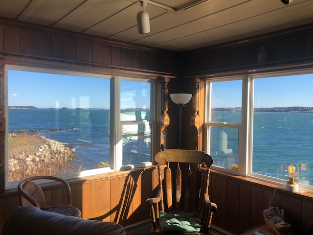 sunroom with a wealth of natural light and a water view