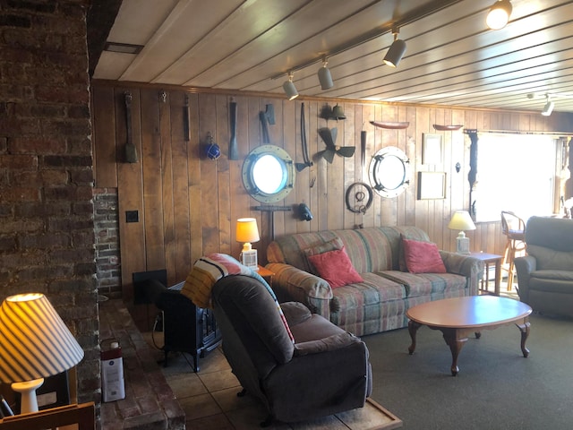 living room featuring wood ceiling, wooden walls, and track lighting