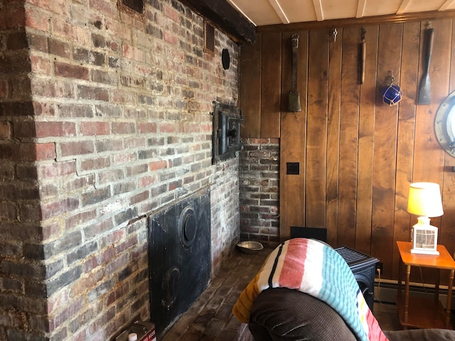 interior space with a fireplace, hardwood / wood-style flooring, baseboard heating, and wood walls