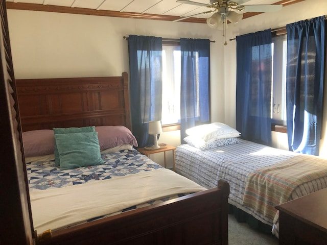 bedroom with ceiling fan, carpet floors, and ornamental molding