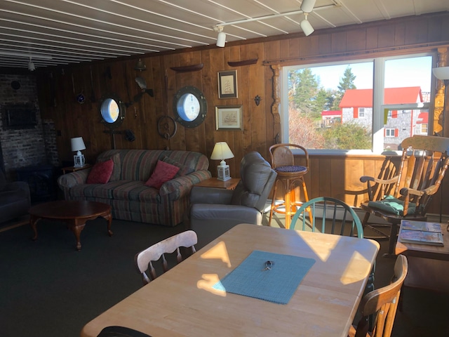 living room with ceiling fan and wood walls