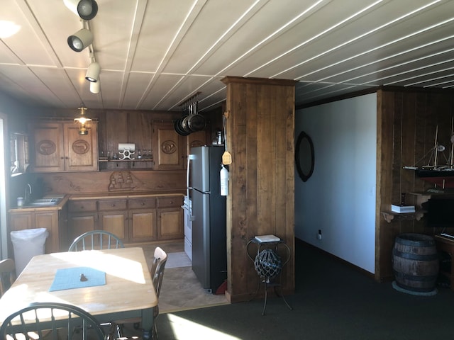 dining area featuring wooden walls and sink