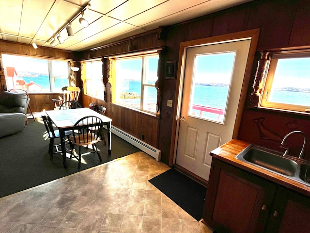 dining room with plenty of natural light, a water view, and baseboard heating