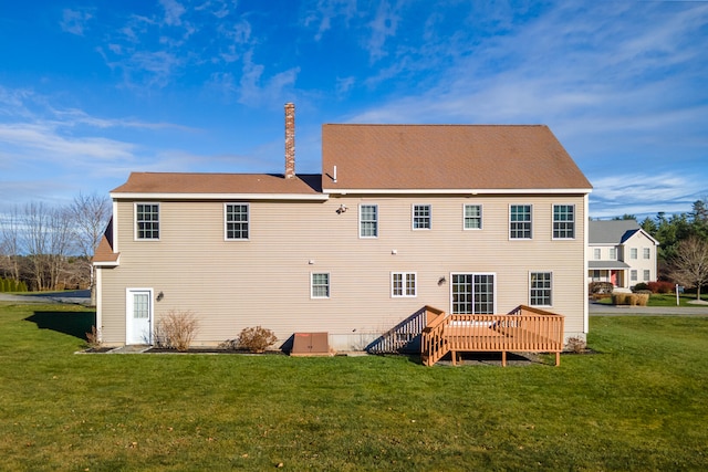 back of property featuring a yard and a wooden deck