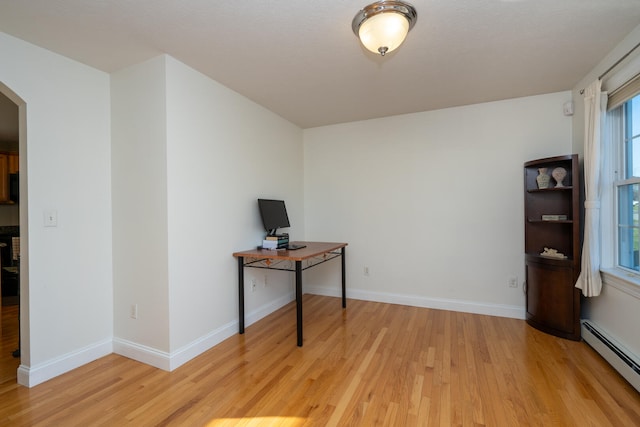 unfurnished office with light hardwood / wood-style flooring and a baseboard heating unit