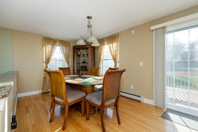 dining room featuring an inviting chandelier, light wood-type flooring, and a baseboard heating unit