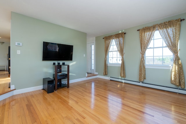 unfurnished living room featuring light hardwood / wood-style floors and a baseboard heating unit