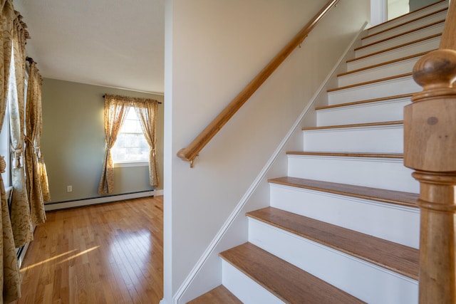 staircase featuring a baseboard radiator and hardwood / wood-style flooring