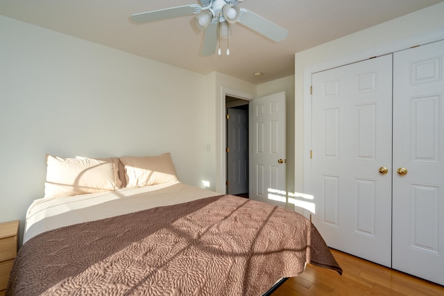 bedroom with ceiling fan, a closet, and wood-type flooring