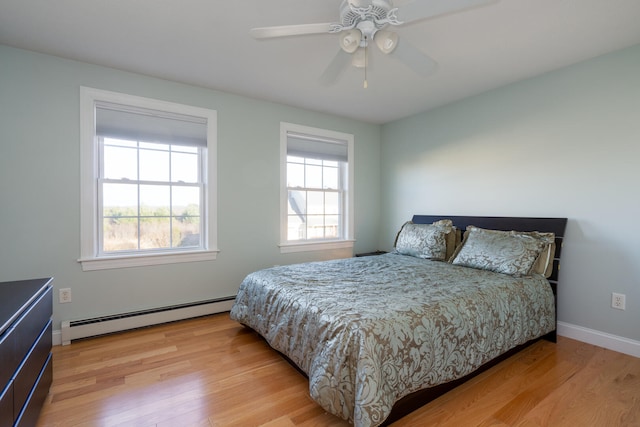 bedroom featuring ceiling fan, light hardwood / wood-style floors, and a baseboard radiator