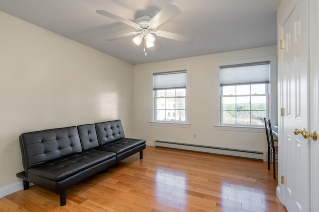 sitting room with ceiling fan, light hardwood / wood-style floors, and baseboard heating