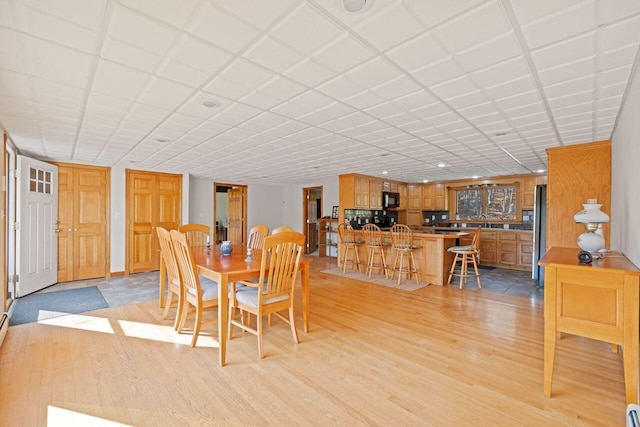 dining space with sink and light hardwood / wood-style floors